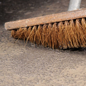 Überschüssigen Sand abkehren